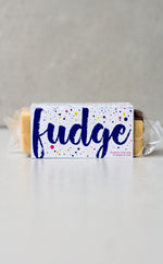 Load image into Gallery viewer, Creme Egg white chocolate fudge in purple branded packaging 
